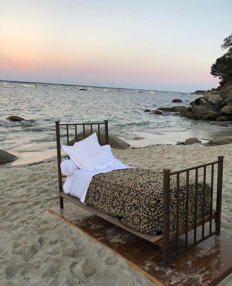 Un lit, au beau milieu de la plage.